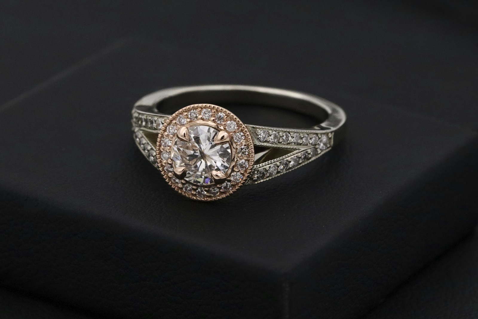 Detalle de un anillo con piedras engastadas sobre fondo oscuro